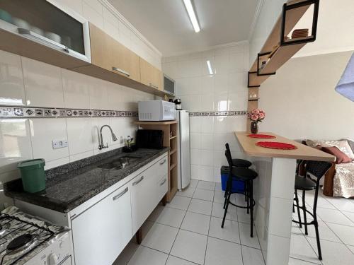 大普拉亚Apto dos Cardeais的一个带水槽和桌子的小厨房
