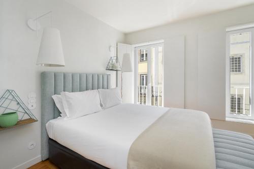 里斯本WHome Top Floor w Luxury Design Premium Location的卧室配有白色的床和2扇窗户。