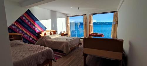 Isla de la LunaWaynapicchu Lodge Isla de la Luna Bolivia的一间卧室设有两张床和大窗户