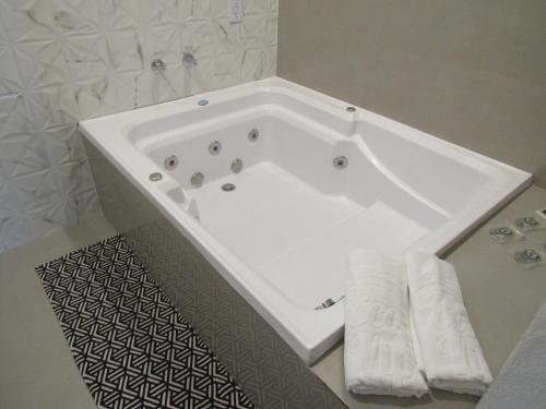 西波山Pousada Meraki的浴室设有白色浴缸,配有毛巾