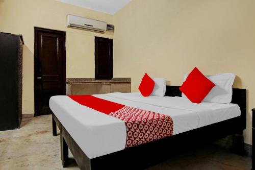 新德里OYO Flagship Hotel B K Palace的一间卧室配有一张带红色枕头的大床