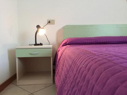 罗索利纳马雷Settimo cielo的一张带紫色毯子的床和床头灯