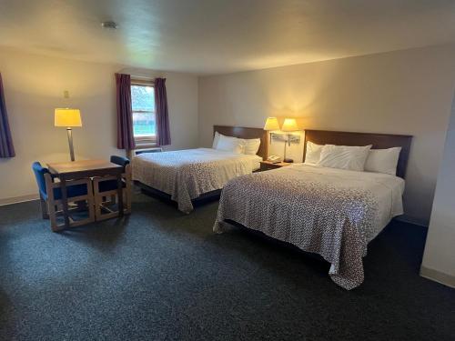 绿湾Bay Motel的酒店客房设有两张床和一张桌子。