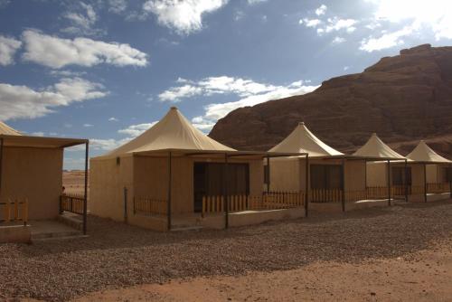 DisahRemal Wadi Rum Camp & Tour的山脚下的一排帐篷