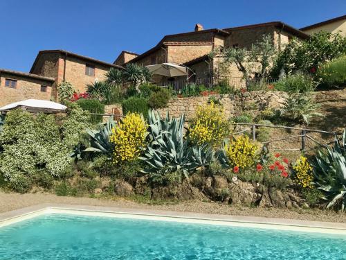 蒙特瓦尔基Ventena Vecchia antico frantoio的一座带花园和游泳池的房子