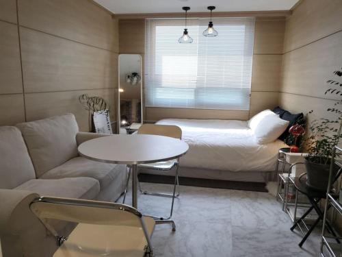 束草市Sokcho Coco的客厅配有沙发、桌子和床。