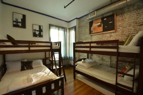 普罗维登斯Michie Hostel的带三张双层床和砖墙的客房