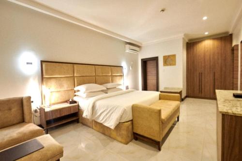 阿布贾MEETHAQ HOTELS MAITAMA的一间大卧室,配有一张大床和一张沙发