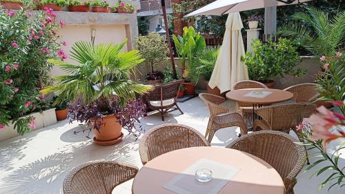索佐波尔罗西别墅的庭院配有桌椅、雨伞和植物