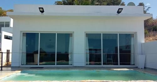 AntsakomboenaRésidence ÉBÈNE的白色的房子,设有玻璃门和游泳池