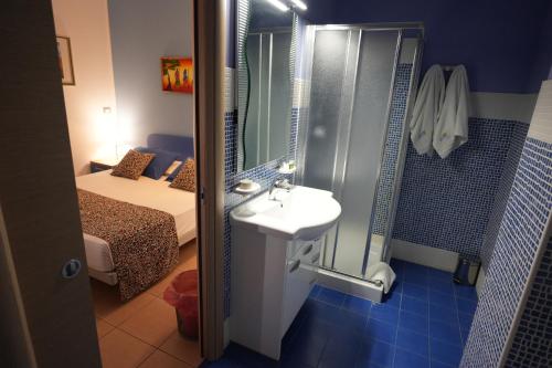 切萨雷奥港B&B Simonetta的带淋浴和盥洗盆的浴室以及1张床。