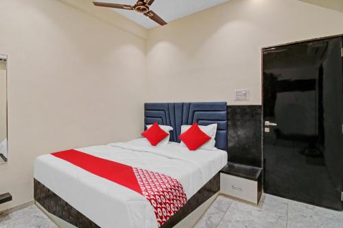 SakardarāFlagship Hotel S R Guest House的一间卧室配有红色枕头的床