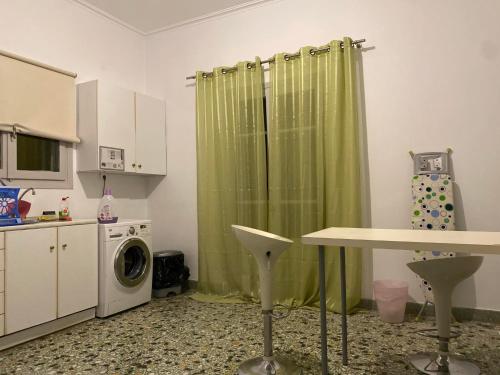 约阿尼纳Lait Hostel的厨房配有绿色的浴帘和洗衣机