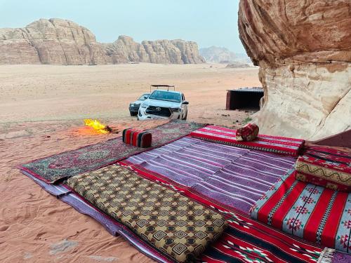 瓦迪拉姆Wadi Rum Story Camp的沙漠中的一张床,沙漠中的一辆汽车