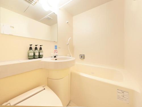 滨松Centurion Hotel Hamamatsu的白色的浴室设有水槽和卫生间。