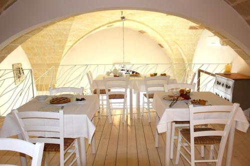 阿莱齐奥Palazzo Aurora的用餐室配有白色的桌子和白色的椅子