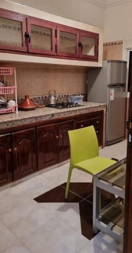 تجزئة القلم حي أطلس بني ملال的厨房配有绿色椅子和柜台