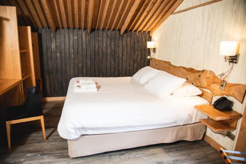 La JuntaAlto Melimoyu Hotel & Patagonia的一间卧室配有一张带白色床单的大床