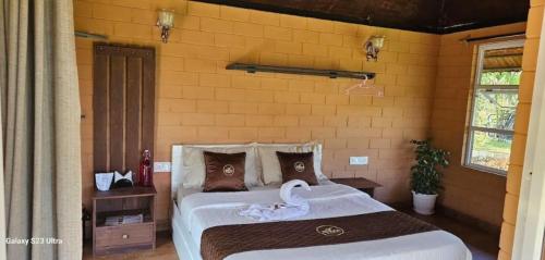 瓦亚纳德Bhuvi Wayanad Natural Tea Plantation Resort的一间卧室配有一张带天鹅的床