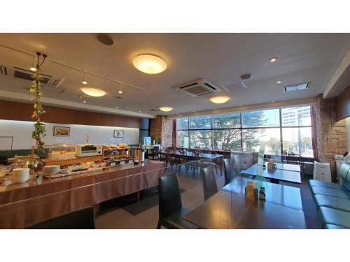 延冈市Nobeoka Urban-Hotel - Vacation STAY 30532v的餐厅设有桌椅和大窗户。