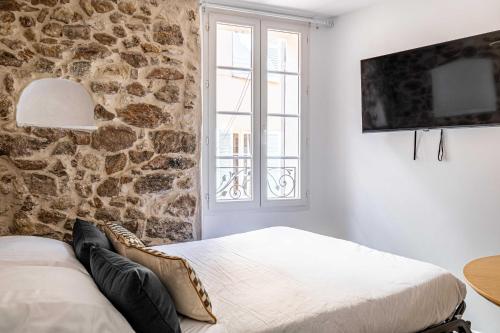 戛纳Cozy renovated 1 bedroom Suquet Cannes Center - 1BR的一间卧室设有两张床和石墙