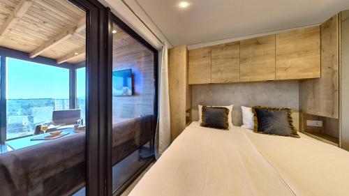 木洛希尼Kasthouse Luxury mobile home Orange的客房设有床、书桌和窗户。