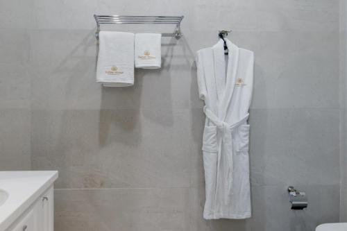 阿斯塔纳Tumar Hansa Ethno Hotel的浴室墙上挂着白色的西装