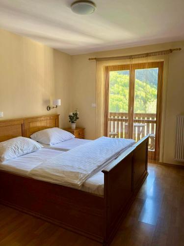 罗格坡曼戈唐Hotel Alpine的一间卧室设有一张大床和一个大窗户