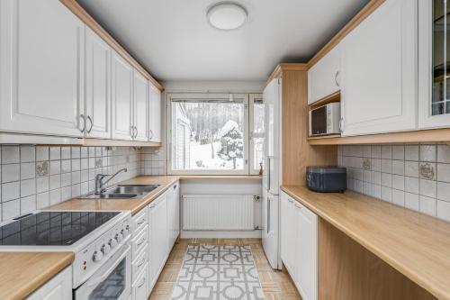 赫尔辛基Private rooms near metro, free parking的厨房配有白色橱柜和窗户。