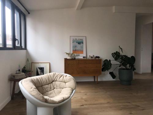 蒙特勒伊Cosy apartment in Montreuil near Paris center的客厅配有白色椅子和植物