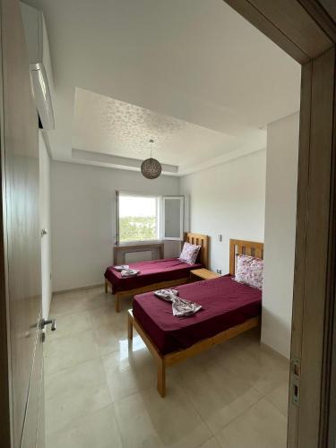 Hammamet SudMaison de vacances的一间卧室设有两张床和窗户。