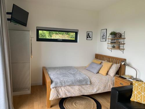 纽伯里Cedar Cabin的一间卧室配有一张床和一台电视