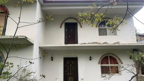 波格拉德茨Bitro House的白色的房子,设有两扇窗户和一扇门