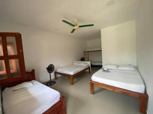 帕洛米诺hotel palmares beach的客房设有两张床和吊扇。