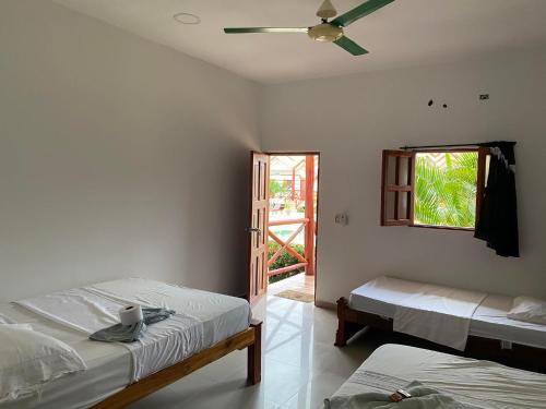 帕洛米诺hotel palmares beach的一间卧室配有两张床和吊扇