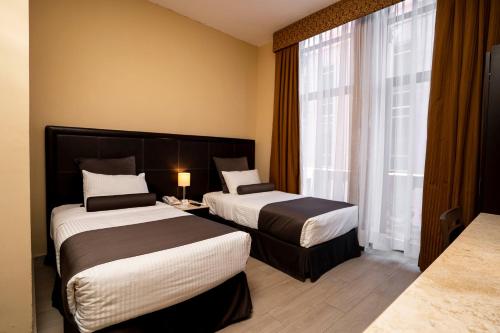 圣路易斯波托西旧金山酒店的酒店客房设有两张床和窗户。