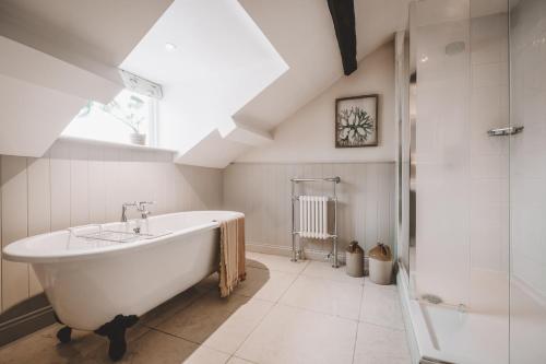 Bowland BridgeThe Hare & Hounds Inn的白色的浴室设有浴缸和淋浴。