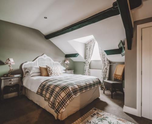 Bowland BridgeThe Hare & Hounds Inn的卧室配有床、椅子和窗户。