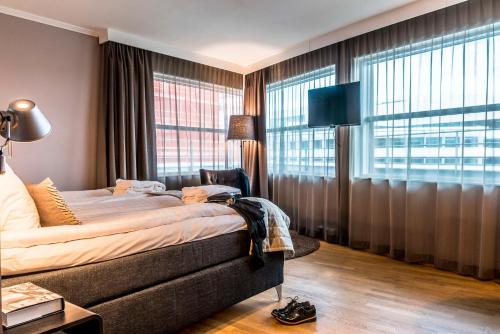 默恩达尔默恩达尔斯堪迪克酒店的一间卧室设有一张床和一个大窗户