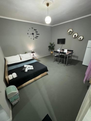 克桑西Best minimal studio in Xanthi - myHomee的一间卧室配有一张床、一张桌子和闹钟