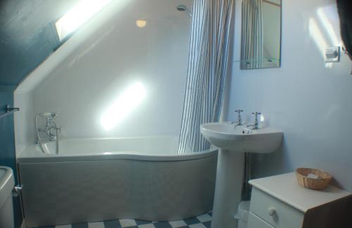 巴里瓦尼奇Comfortable detached 4 bedroomed holiday home的浴室配有盥洗盆、浴缸和盥洗盆