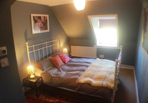 巴里瓦尼奇Comfortable detached 4 bedroomed holiday home的一间卧室配有一张带两盏灯的床和一扇窗户。