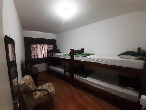 布拉干萨-保利斯塔Pousada Malu的一间卧室配有一张床、一张桌子和一把椅子