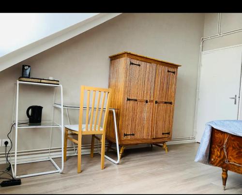 昂热Chambre privée的一间卧室配有书桌、木制橱柜和椅子