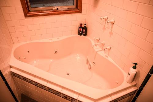 托基贝丝艾斯特大洋公路小屋酒店的带窗户的浴室内的白色浴缸