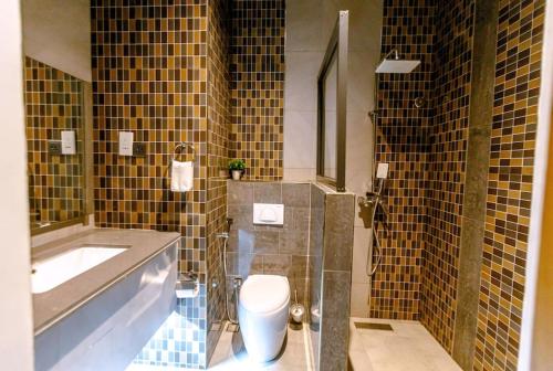 达累斯萨拉姆Serenity Suite With free Wi-Fi and Swimming pool的浴室配有卫生间、浴缸和水槽。