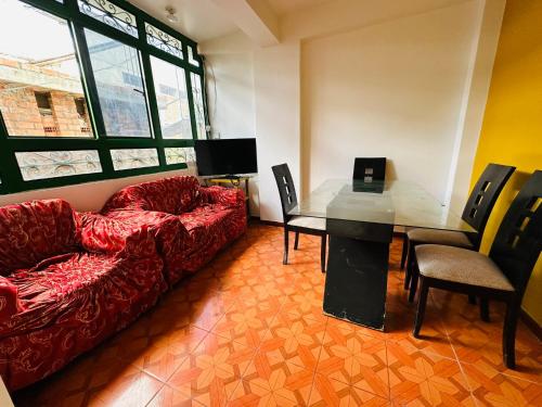 瓦拉斯Kayac Hostel的客厅配有红色的沙发和桌子
