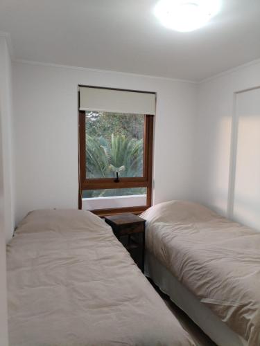 普孔Departamento con exelente ubicacion的一间卧室设有两张床和窗户。