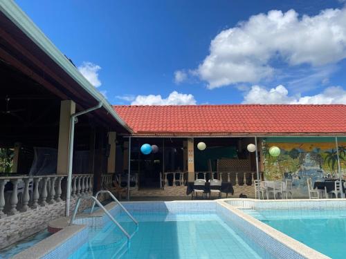 GuácimoHotel y restaurante Tabaconess的红色屋顶的度假村游泳池