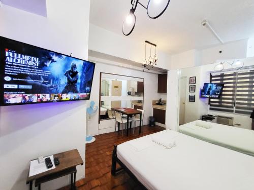 马尼拉Bright Makati Glass View By GreenBelt的一间设有床铺和墙上电视的房间